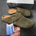 Birkenstock Boston clogs in a green suede with a Stüssy collaboration logo